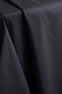 Tissu coton déperlant anthracite avec un fuseau de fil assorti et des boutons ton sur ton posés dessus.