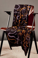 Chaise vintage en bois entièrement recouverte du tissu Misty noir à motif de lignes sinueuses lilas et moutarde.