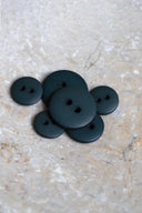 Close-up of the same buttons on the edge of a marbled beige stone.