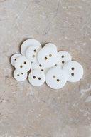 Close-up of the same buttons on the edge of a marbled beige stone.