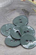 Gros plan sur les mêmes boutons en émail brillant, vue rapprochée révélant la texture lisse et la brillance de la matière.