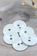 Gros plan sur les mêmes boutons en émail brillant, vue rapprochée révélant la texture lisse et la brillance de la matière.