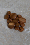 Les boutons vus de dessus, empilés au centre d'une pierre beige marbrée.