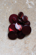 Les boutons vus de dessus, empilés au centre d'une pierre beige marbrée.