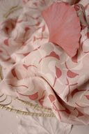 Feuille de ginkgo séchée rose posée sur le tissu Windy rose poudré, à motif de feuilles courbes terracotta et écru.