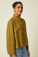 Amirale Shirt pattern – Woman, 3/4 view, khaki loose-fitting shirt worn with jeans, beige background – Atelier Brunette