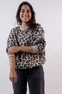 Patron Le Hoodie – Femme de face souriante, sweat oversize imprimé léopard beige et vert, bras croisés – Atelier Brunette