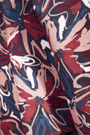 Tissu Hilma River plié, avec une bobine de fil bleu en bois et un dessous-de-plat en osier contenant des boutons noirs.