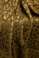 Gros plan sur le tissu jacquard Leony kaki doré, détaillant le motif léopard tissé en relief et le fini satiné du fil.