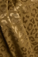 Tissu jacquard de viscose Leony imprimé léopard camel et doré, drapé en plis souples mettant en valeur son fini satiné.